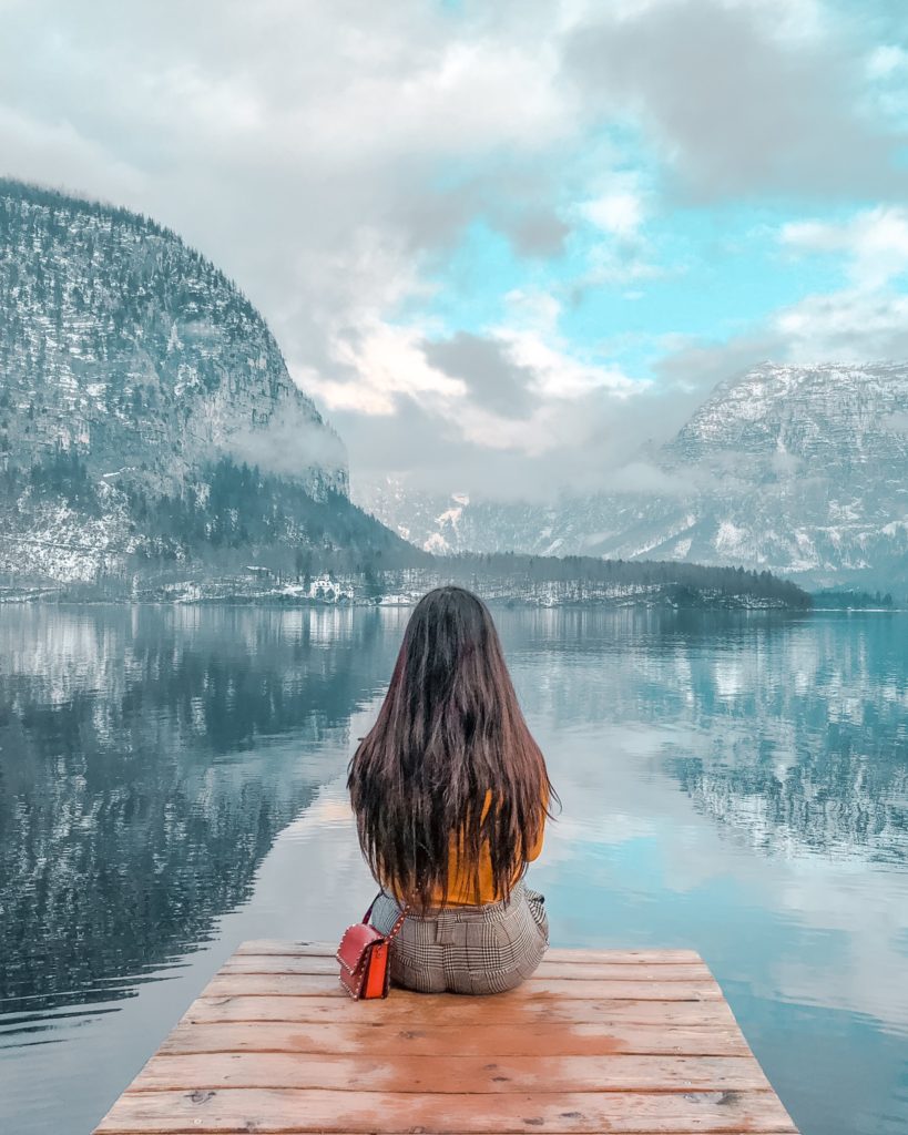 picture of myself sitting by the lake in Hallstatt and admiring the reflections of the beautiful mountains that surround it.