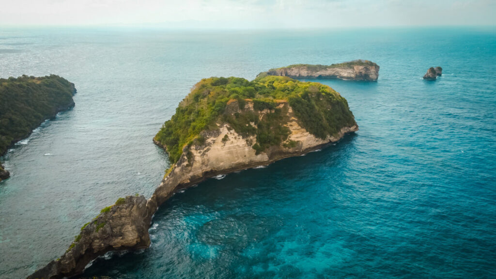 A drone shot of small islands in the sea near Nusa Penida.